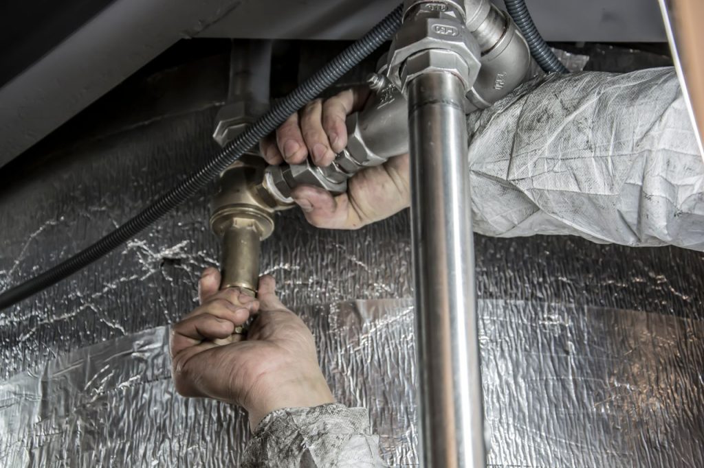 Crafting Captivating Headlines: Your awesome post title goes here Close-up of a plumbers hands installing steel pipes indoors, showcasing skilled manual work.
